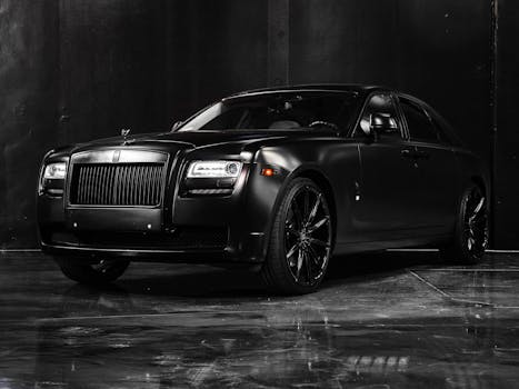 Expensive elegant fashioned new black car with headlights square parked on marble floor in showroom